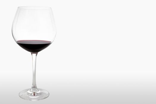 Horizontal shot of a glass of red wine on white background.