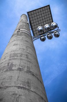 A lighting system alternatively composed of a reflective panel, installed on an old chimney.