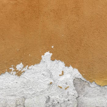Fragment of wall with broken stucco. Old brown wall with damaged shabby color plaster. Distressed wall background. Concept of renewal, of restore and repair.