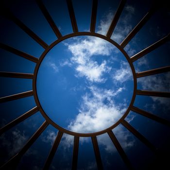 Bottom view of an iron structure, with blue sky in the background.