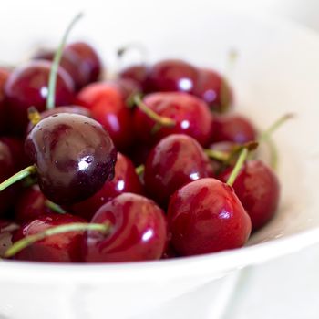 Close-up of sweet cherries in a white bowl.