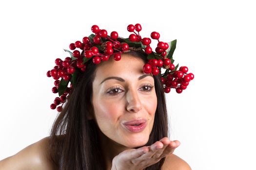 Christmas or New Year beauty woman portrait isolated on white background. Smiling young woman with wearing a Christmas wreath on her head, send a kiss. Natural makeup.