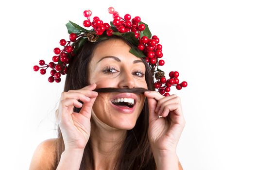 Christmas or New Year beauty woman portrait isolated on white background. Smiling young woman with wearing a Christmas wreath on her head, playing with her hair. Natural makeup.