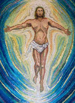 Religious mosaic of Jesus Christ, with open arms and eyes to the sky. The painting is multicolored. It can be used for backgrounds or concepts.