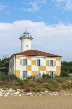 Bibione / Italy - August 24 ,2018: Lighthouse on the Adriatic riviera, against a blue sky with white clouds.