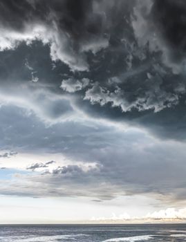 Landscape photo of a beach and dramatic thunderstorm clouds over the sea or the ocean