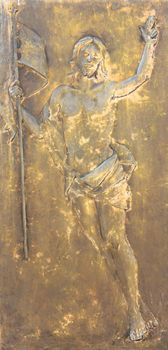 Figure of Jesus Christ in bronze bas-relief. The Redeemer holds a flag in his hand. Ideal for concepts and backgrounds