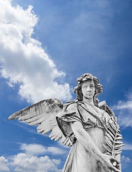 Statue of an angel with olive branches with sky and clouds in the background