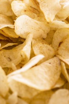 Crispy chips golden pattern. Yellow salted potato chips as background.