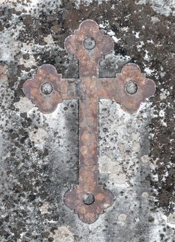 Ancient rusty cross on a old stone. Ideal for concepts and backgrounds.