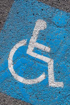 Close - up of disabled parking sign painted on tarmac. Ideal for concepts and backgrounds.