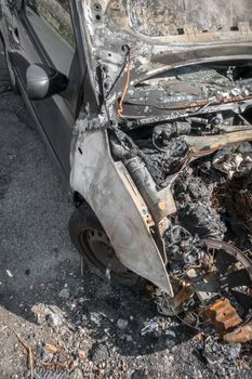 Burnt car on a city street. View from above.