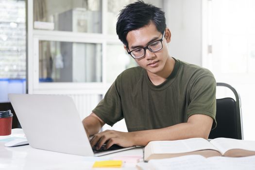 Young collage student using computer and mobile device studying online. Education and online learning. 