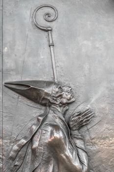 Bas-relief of an old pope in prayer on the bronze door of a church