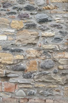 Ancient wall made up of irregular stones with warm colors