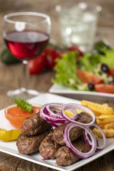 cevapcici on a plate on wood