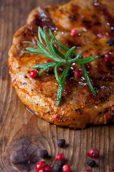 pork steak with pepper corns on wood