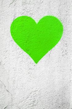 Green love heart hand drawn on grungy wall. Textured background trendy street style. Copy space.