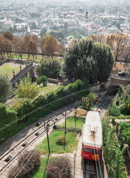 Upper city funicular line in Bergamo (Funicolare Citta Alta). Red funicular connects old Upper City and new. Scenic view of Bergamo historical center. Bergamo (upper town), ITALY - October 5, 2019