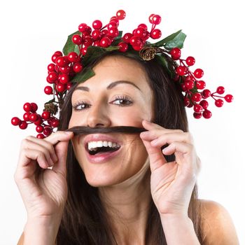Cute Santa woman with a Christmas wreath on her head makes a grimace, mustache of hair and looks at camera on white background. Expressive facial expressions emotions.