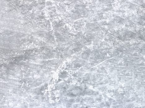 Close up of white ice surface with a traces left by the skates. Ideal for texture and backgrounds.