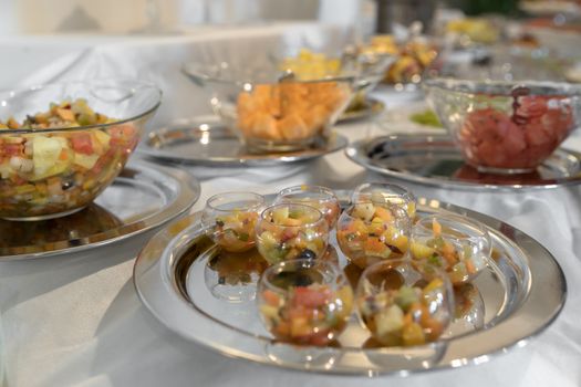 Beautifully decorated catering banquet table with different food fresh fruits for parties, events or wedding celebration, served on silver plate.