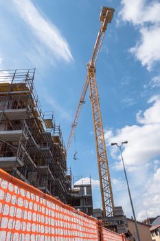 Extensive scaffolding providing platforms for work in progress on a new apartment block. Construction site. Housing crane operation. High rise Building Under Construction.