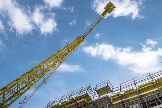 Extensive scaffolding providing platforms for work in progress on a new apartment block. Construction site. Housing crane operation. High rise Building Under Construction.