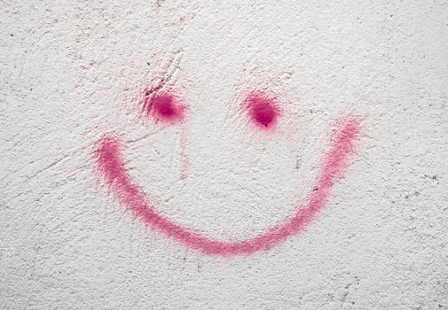 Concrete wall with pink smiley, background for many uses.