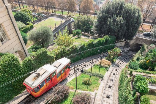 Upper city funicular line in Bergamo (Funicolare Citta Alta). Red funicular connects old Upper City and new. Scenic view of Bergamo historical center. Bergamo (upper town), ITALY - October 5, 2019