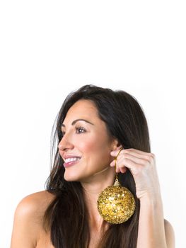 Atracctive young woman holds a golden Christmas ball as earring. Christmas and decor concept.