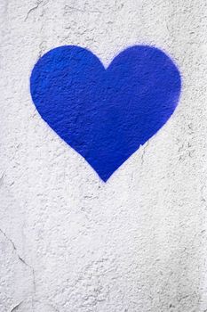 Blue love heart hand drawn on grungy wall. Textured background trendy street style. Copy space.