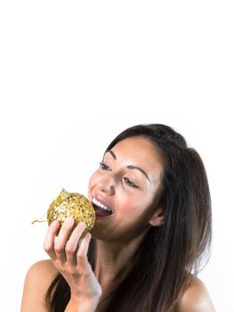 Beautiful young woman playing with a with a golden Christmas ball. Copy space. Ideal for Christmas or New Year holidays.