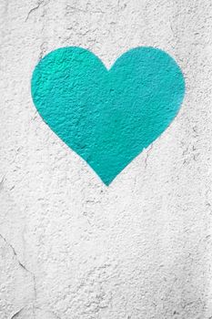 Turquoise blue love heart hand drawn on grungy wall. Textured background trendy street style. Copy space.