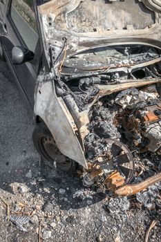 Burnt car on a city street. Busted engine. View from above.