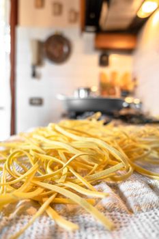 Freshly prepared Tagliatelle pasta closeup. Pasta fettuccine with wheat. Selective Focus. Defocused blurry background.