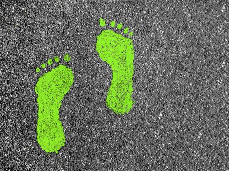 Green footprint signs on an asphalt road for pedestrian. Symbol of walkway.