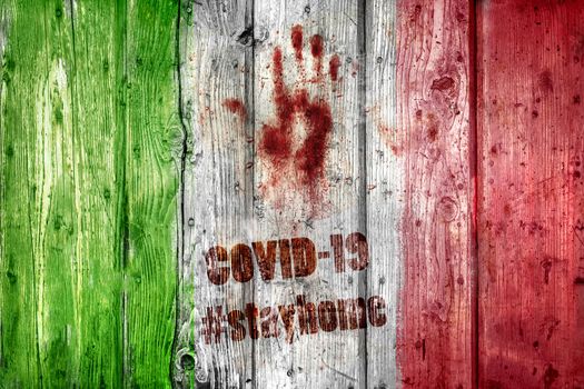 Wooden italian flag with hashtag STAYHOME. Coronavirus in Italy. COVID-19 alert banner with grungy wooden italian flag and bloody handprint. 2019 Coronavirus concept, for an outbreak occurs in Wuhan - China.