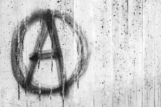 Symbol of Anarchy painted on a grungy concrete wall. Ideal for concepts and backgrounds.