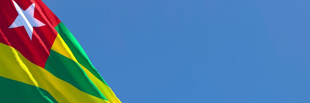 3D rendering of the national flag of Togo waving in the wind against a blue sky