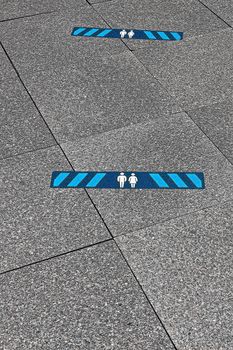 Blue marking on street in order to guide social distancing due to coronavirus or covid-19 pandemic. Blue marking indicating how much distance people should keep to be safe. 2.0 meters