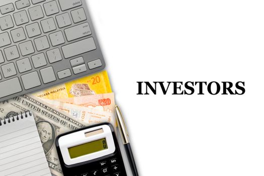 INVESTORS text with fountain pen, keyboard, calculator, notepad and currency banknotes on white background. Business Concept