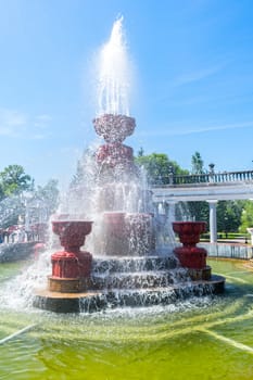 Summer fountain and pool in the city park against the blue sky