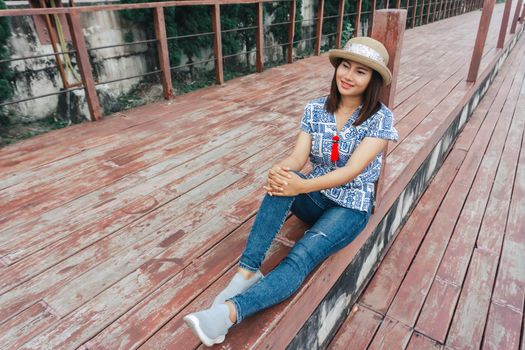 Portrait of asian happy woman smiling with wooden bridge, Selective focus