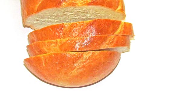 sliced loaf of white wheat bread on a white background top view