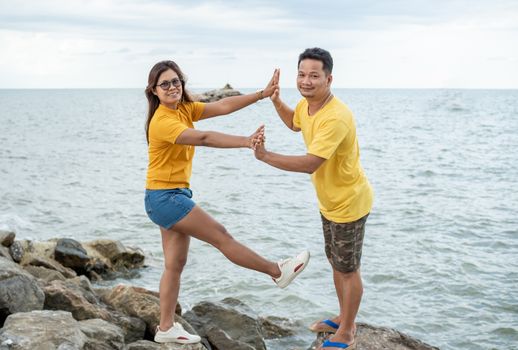 A couple standing on a rock On the background of the sea