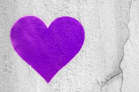 Purple love heart hand drawn on grungy wall. Textured background trendy street style.