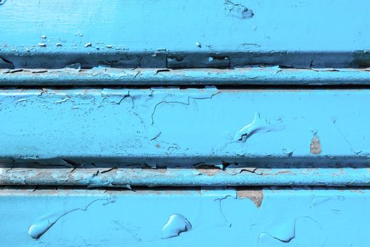 Background of old metal sheet with peel paint texture surface. Painted metal roller shutters door with peeling paint dirty blue hue. Grungy background texture.