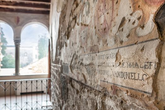 Detail of medieval fresco with Latin inscription. Bergamo, Italy.