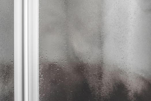 Wet shower stall. Drops of water on the glass. Drops of water flow down the misted glass.